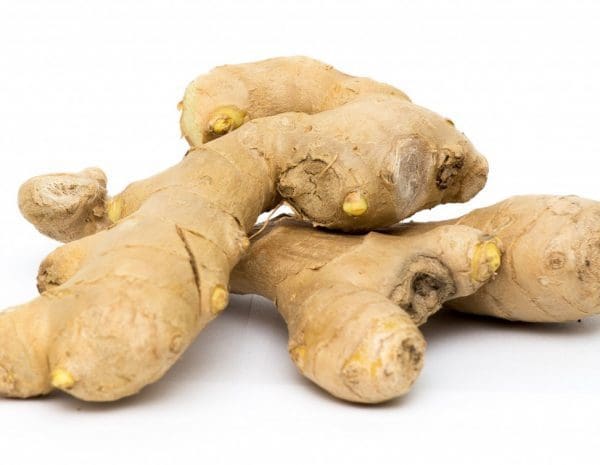 A couple peices of clean, fresh ginger root against a white background